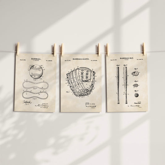 Three vintage-style baseball patent art prints are clipped to a string against a white wall, with soft window shadows cast across the scene.