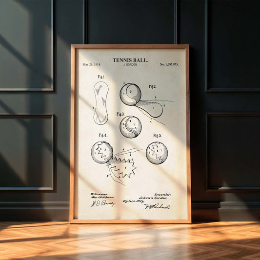 Framed tennis ball patent poster on a wooden floor with a dark paneled wall background