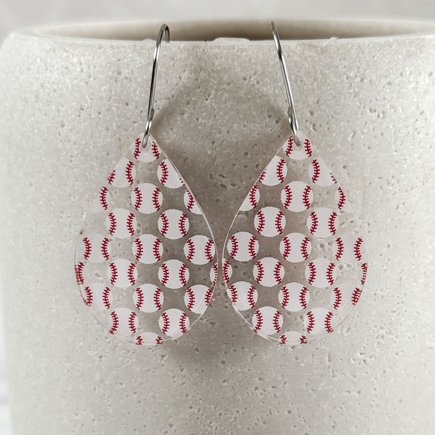 Teardrop-shaped earrings with baseball pattern on a white background