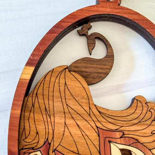 Close-up of engraved peacock feathers and layered cedar, cherry, maple and walnut wood