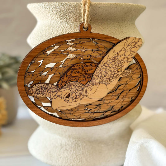 Wooden ornament with turtle design hanging on a white vase.