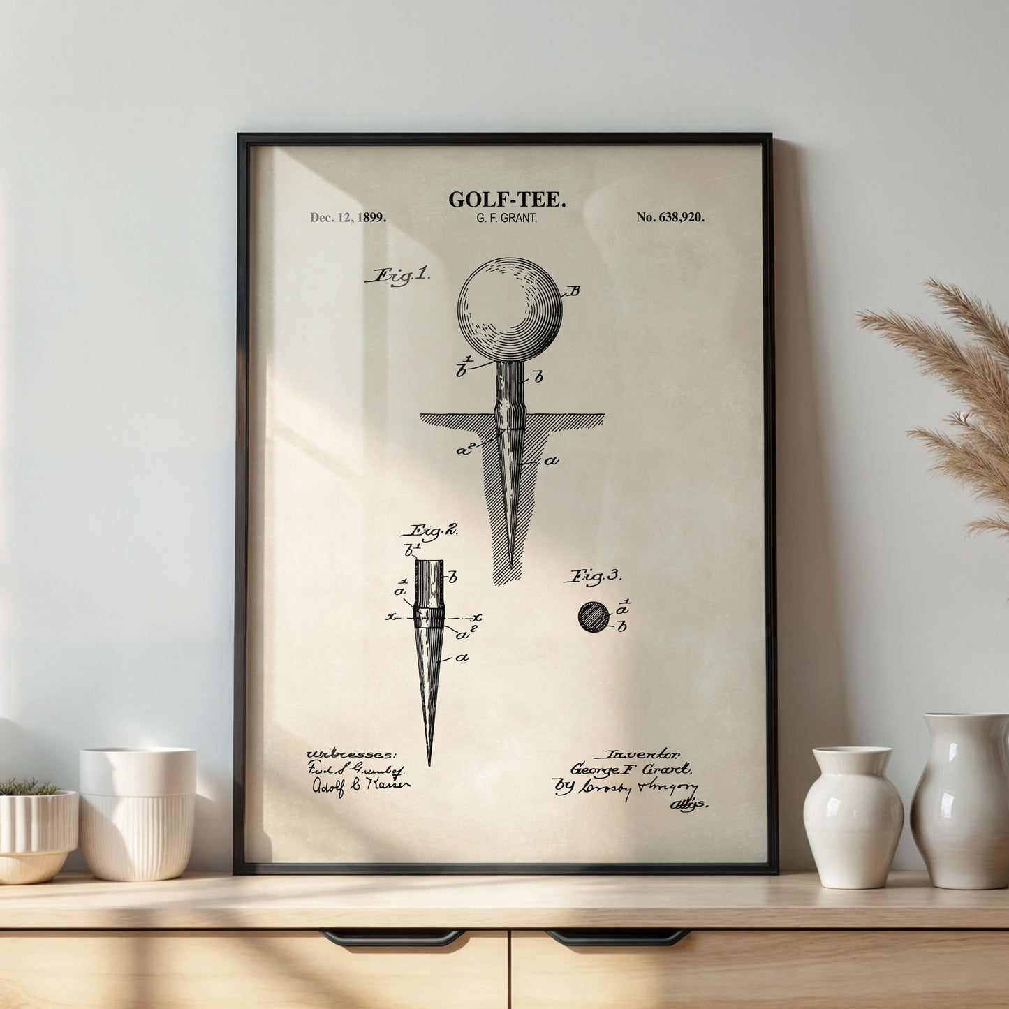 Framed vintage golf tee patent poster on a desk