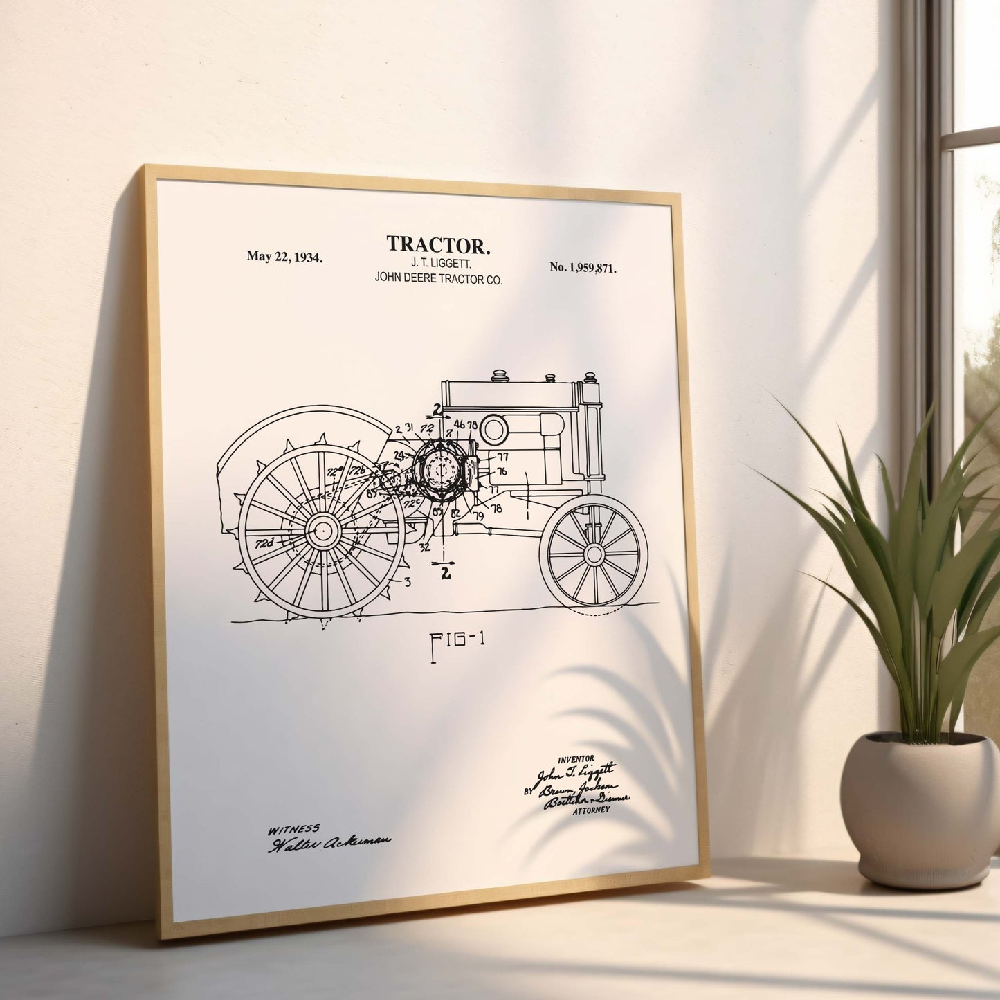 Framed tractor patent print on a wall with a plant in the corner