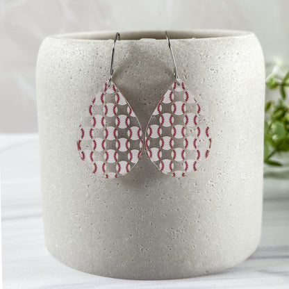 Teardrop-shaped earrings with a baseball pattern hanging from a white container