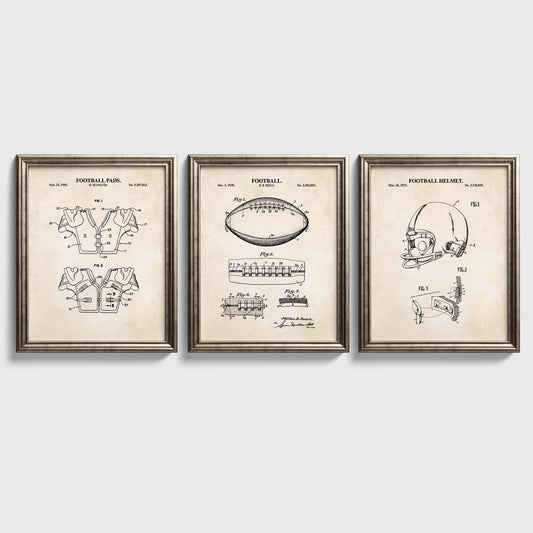 Three framed vintage football patent art prints are displayed side-by-side on a light gray wall. The prints feature black technical line drawings of a football pad, football, and football helmet on an aged beige background, enclosed in matching silver frames.