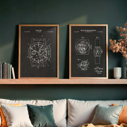 Two framed watch patent art prints with white technical drawings on a dark chalkboard-style background, displayed on a wooden shelf above a sofa with neutral-toned pillows in a styled living room setting.