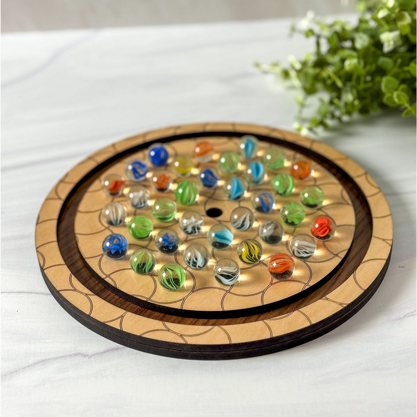 Wooden board game with colorful marbles on a white surface