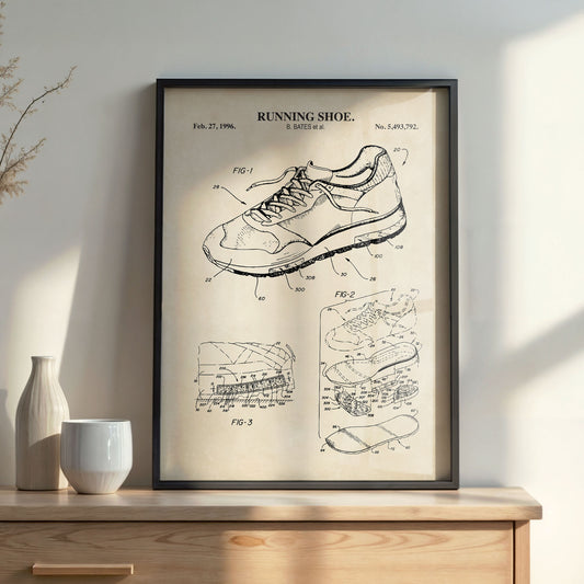 Framed poster of a running shoe patent on a wooden surface with decor items.
