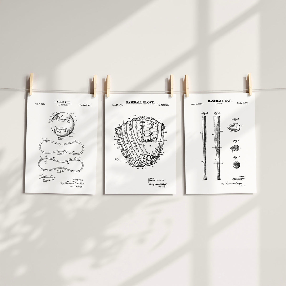 Three white baseball-themed patent art prints clipped to a string against a light wall with soft shadow overlays.