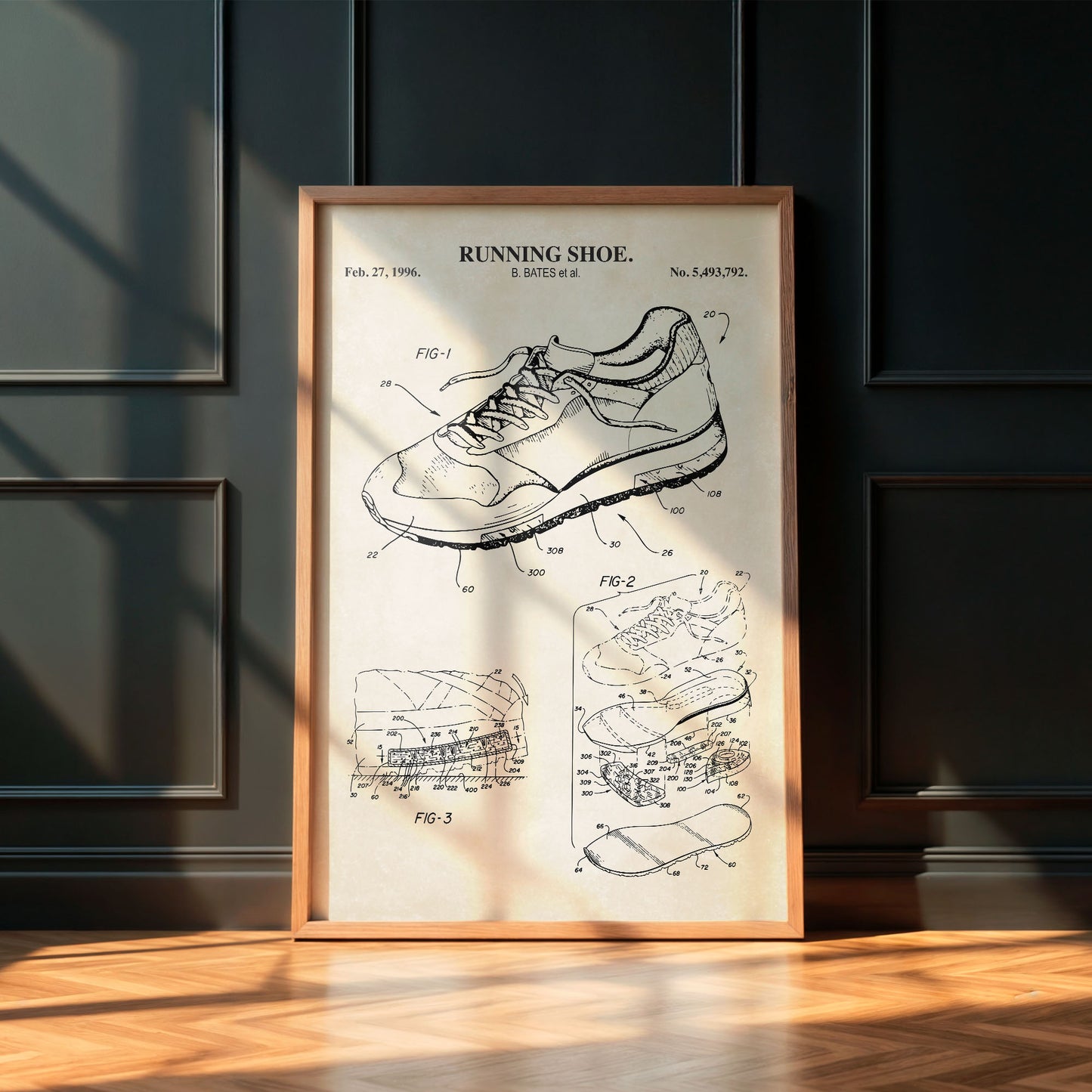 Framed poster of a running shoe patent on a wall with wooden floor