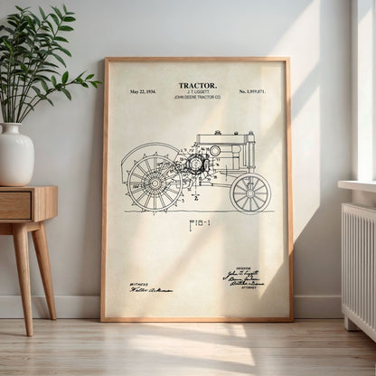 Framed tractor blueprint on a wall in a room with a plant and wooden side table.