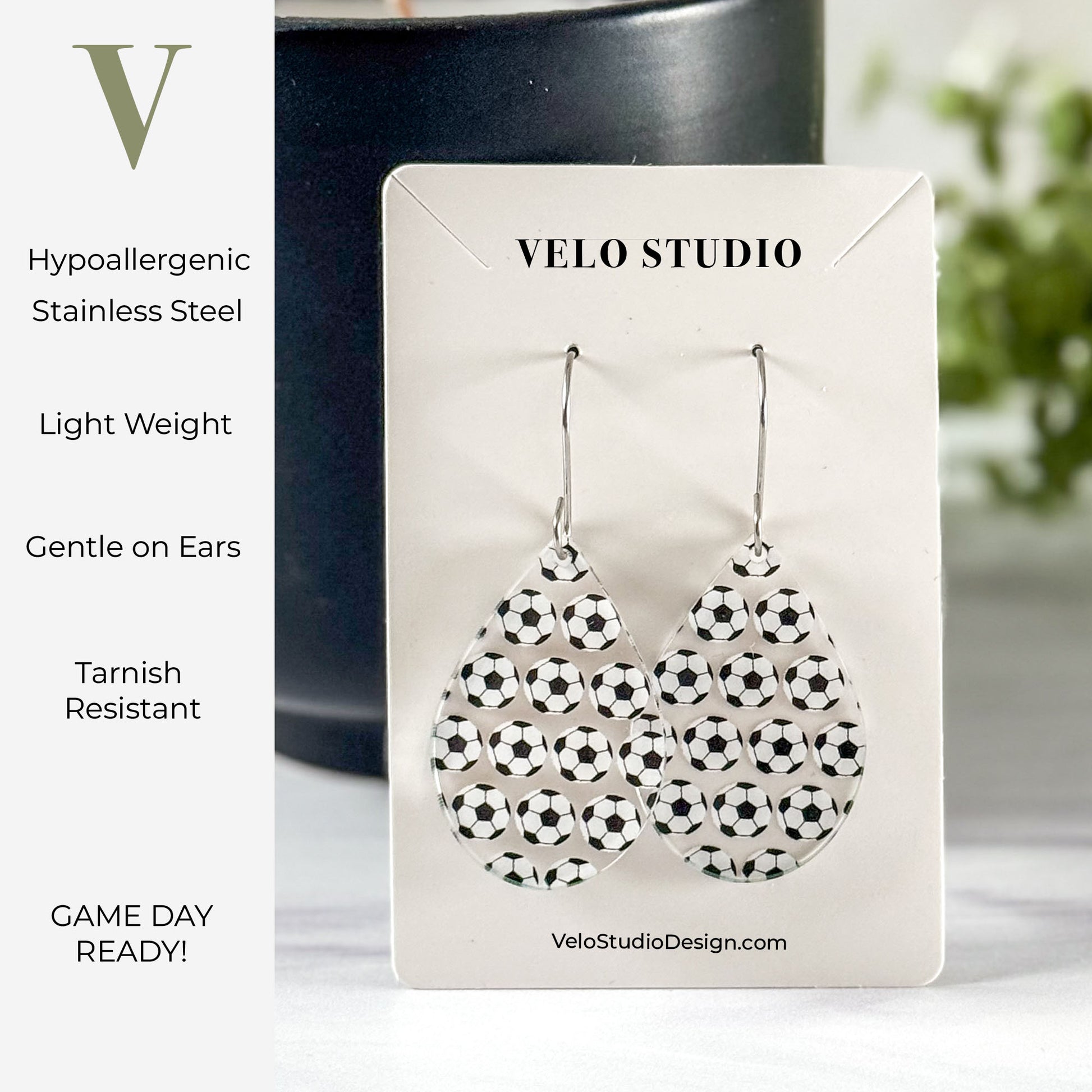 Teardrop shaped earrings  with soccer balls on a Velo Studio card with product features listed.