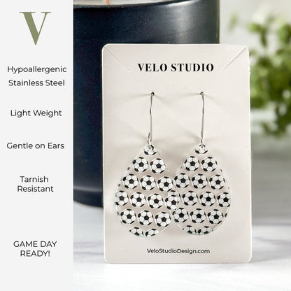 Teardrop shaped earrings  with soccer balls on a Velo Studio card with product features listed.