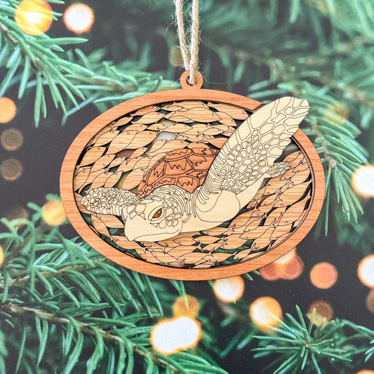 Wooden ornament with turtle design hanging on a Christmas tree.
