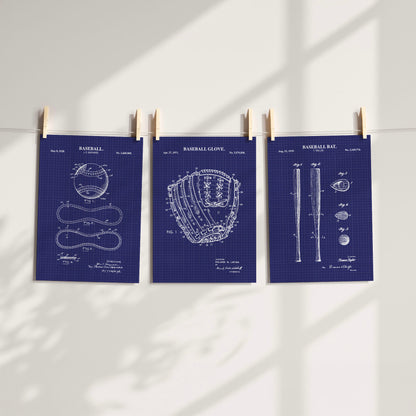 Three navy blue baseball-themed patent art prints clipped to a string against a white wall with soft window shadow overlays.