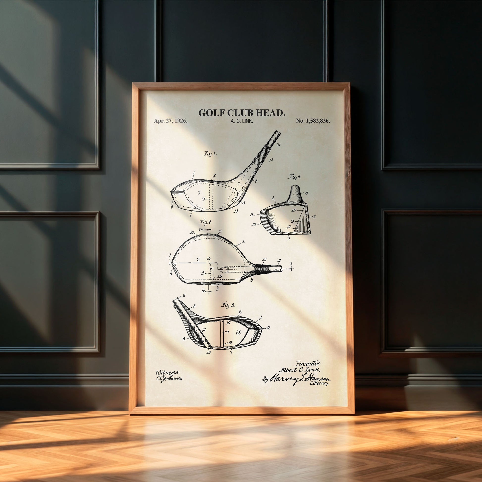 Framed golf club head patent print on a wall with wooden floor