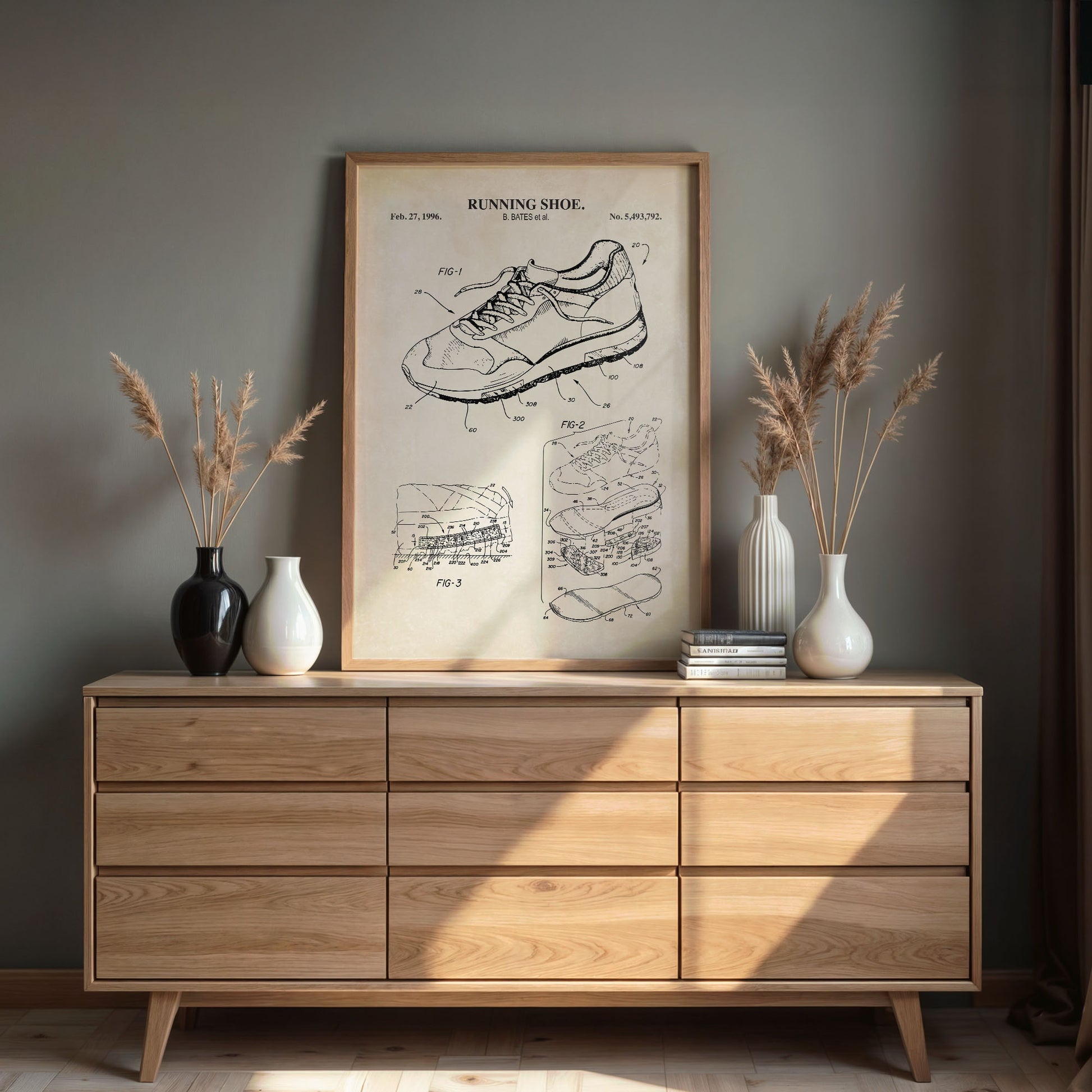 Wooden dresser with framed running shoe patent print and decorative items.