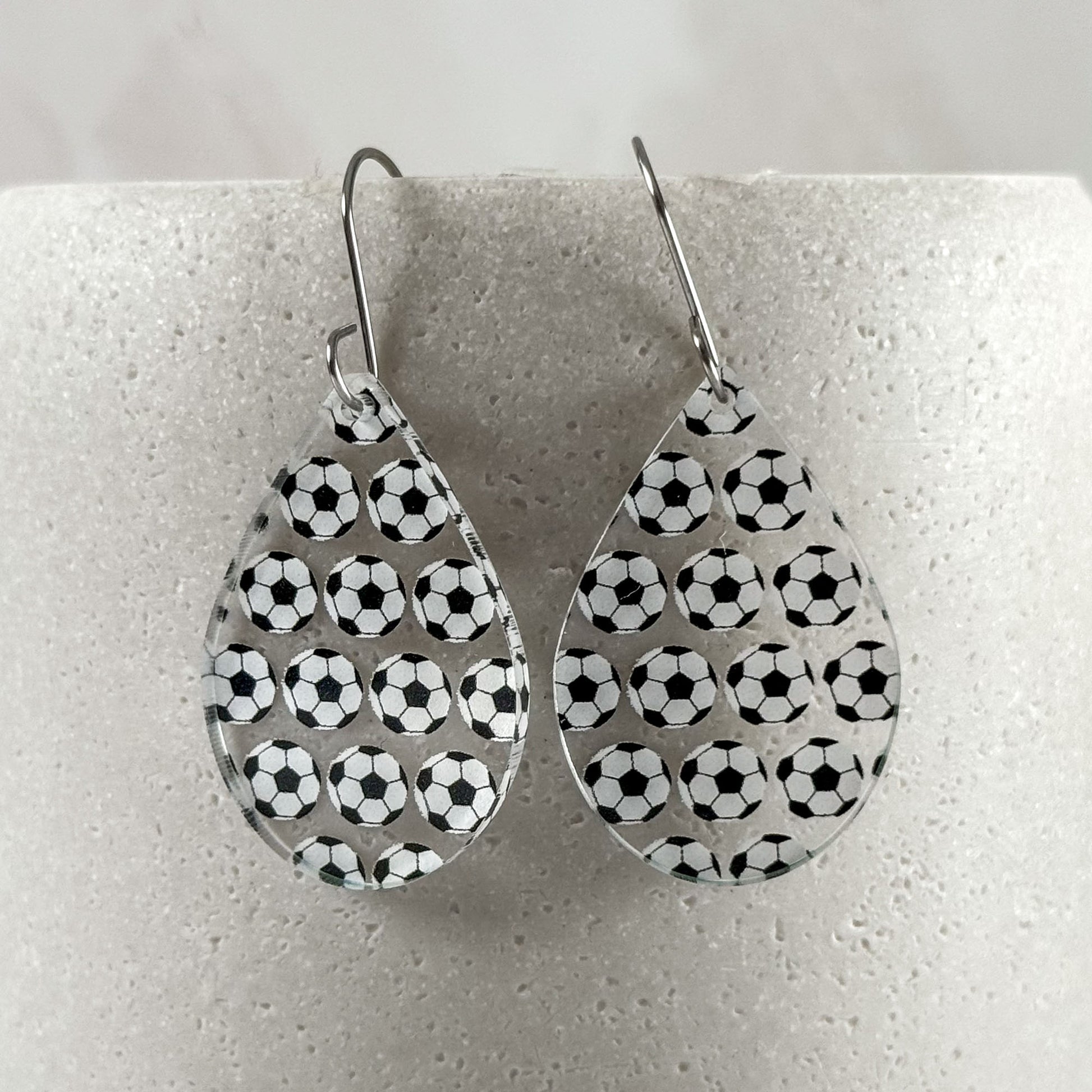 Teardrop-shaped earrings with soccer ball pattern on a white background