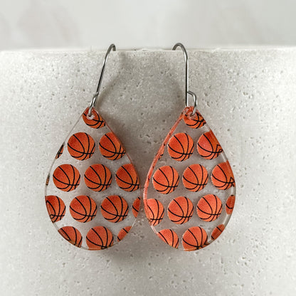 Teardrop-shaped earrings with basketball pattern on a light gray background