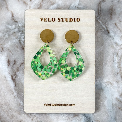 Green patterned earrings on a Velo Studio card against a marble background
