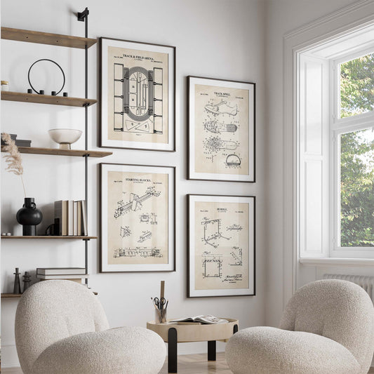 Modern living room with framed track and field patent drawings on the wall, two armchairs, and a window.