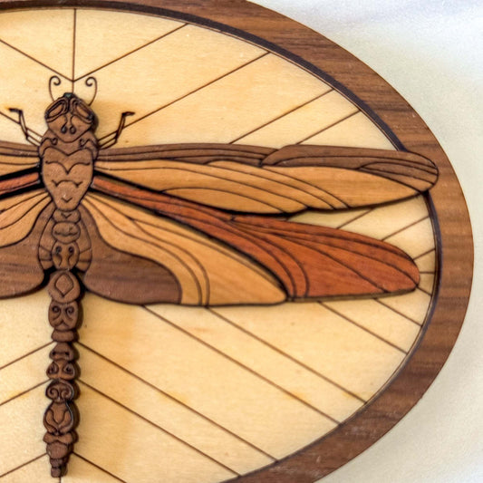 Close-up of intricate dragonfly wings and engraved layered wooden design