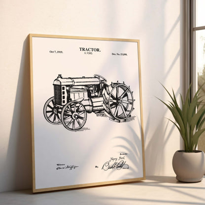 Framed poster of a vintage tractor design on a light surface with a plant in the background