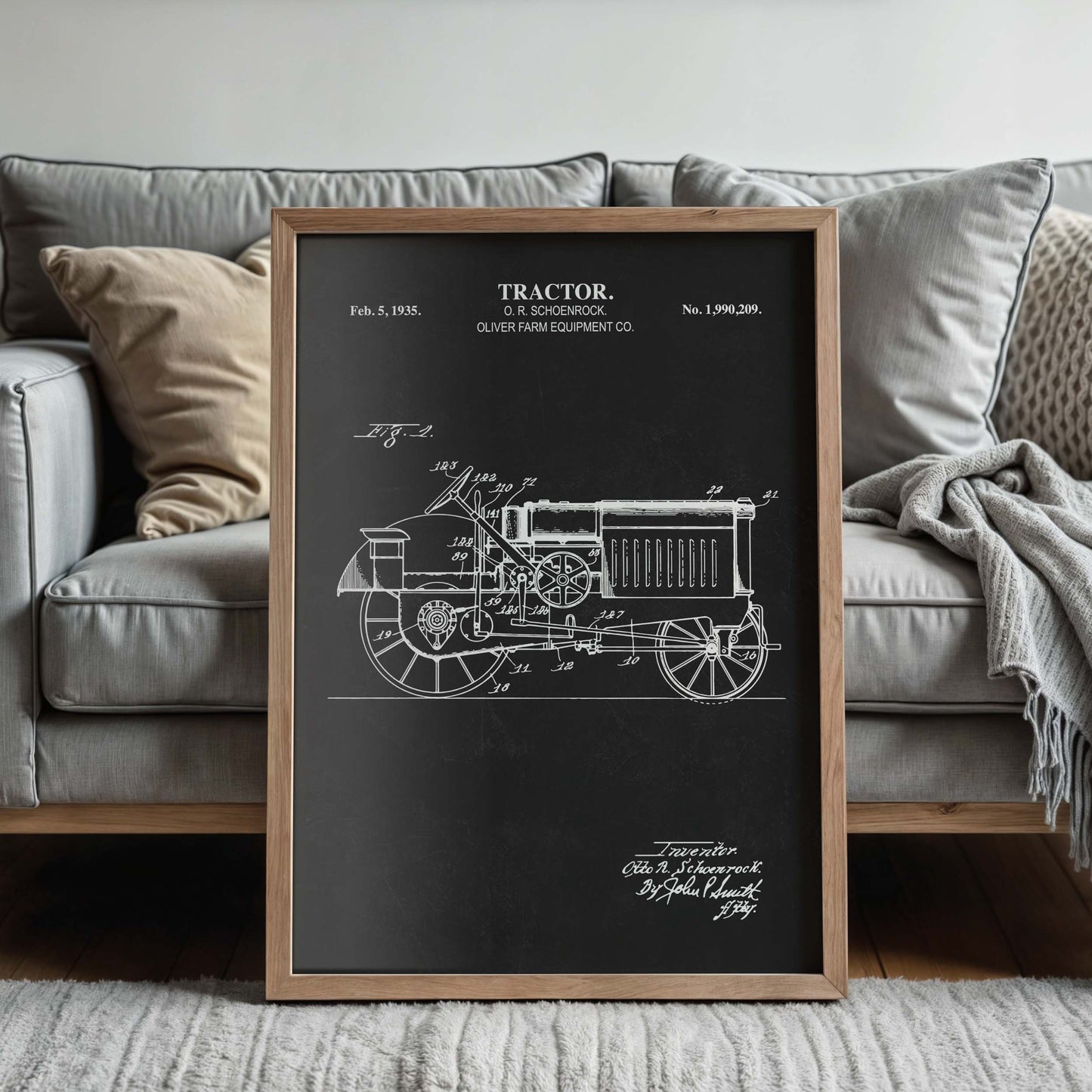 Framed tractor blueprint in front of a couch in a living room setting