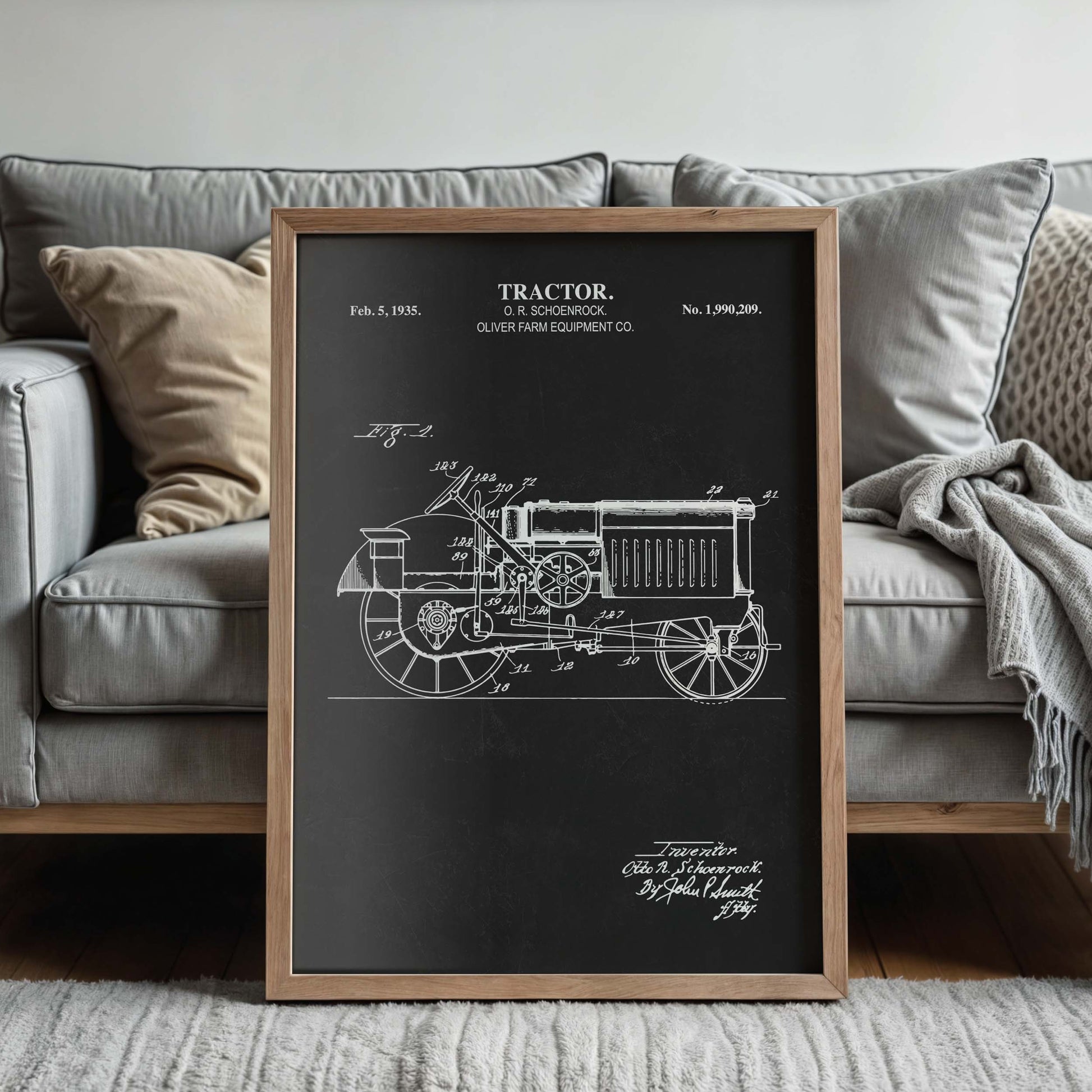 Framed tractor blueprint in front of a couch in a living room setting