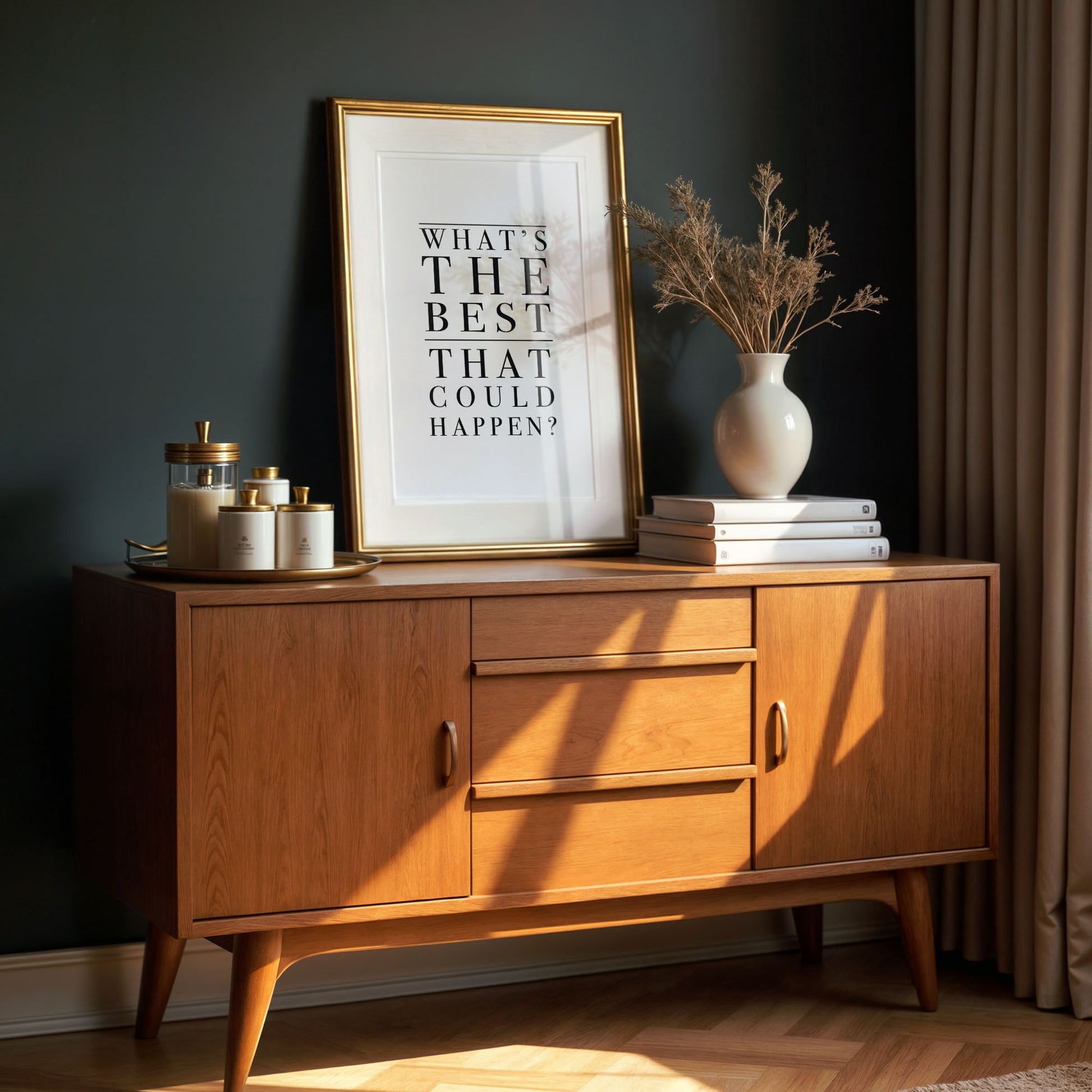 Wooden sideboard with framed quote - what's the best that could happen - and decorative items against a dark wall
