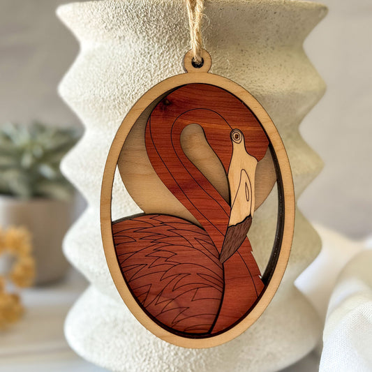 Handcrafted flamingo wood wall charm displayed against neutral ceramic home decor