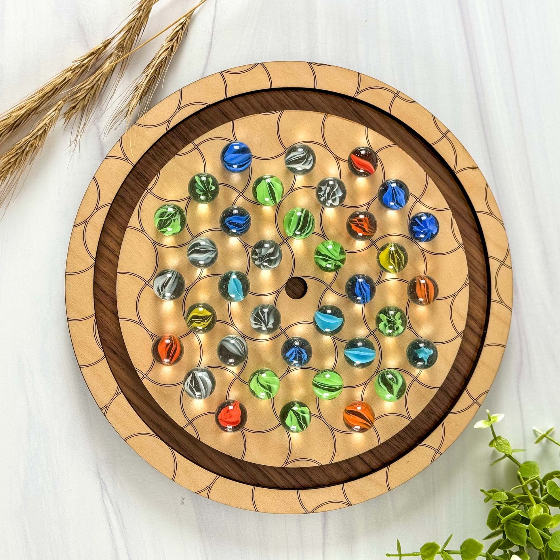Wooden board -marble solitaire -with colorful marbles on a light background