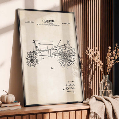 Framed tractor blueprint on a wooden surface with decorative items.