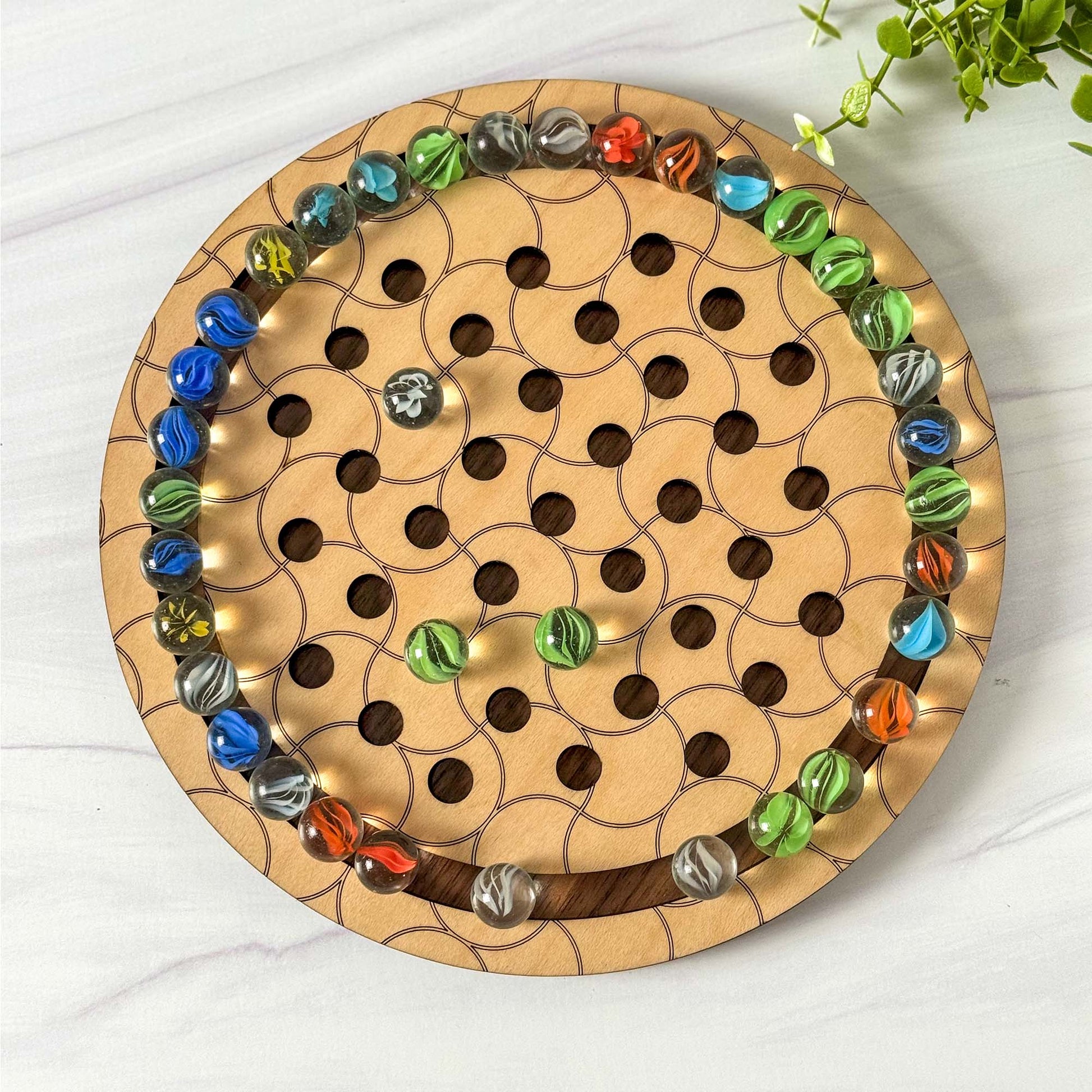 Wooden marble solitaire game with colorful marbles 