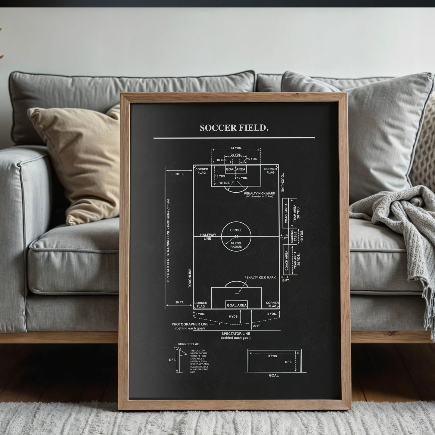 Framed diagram of a soccer field on a gray sofa background