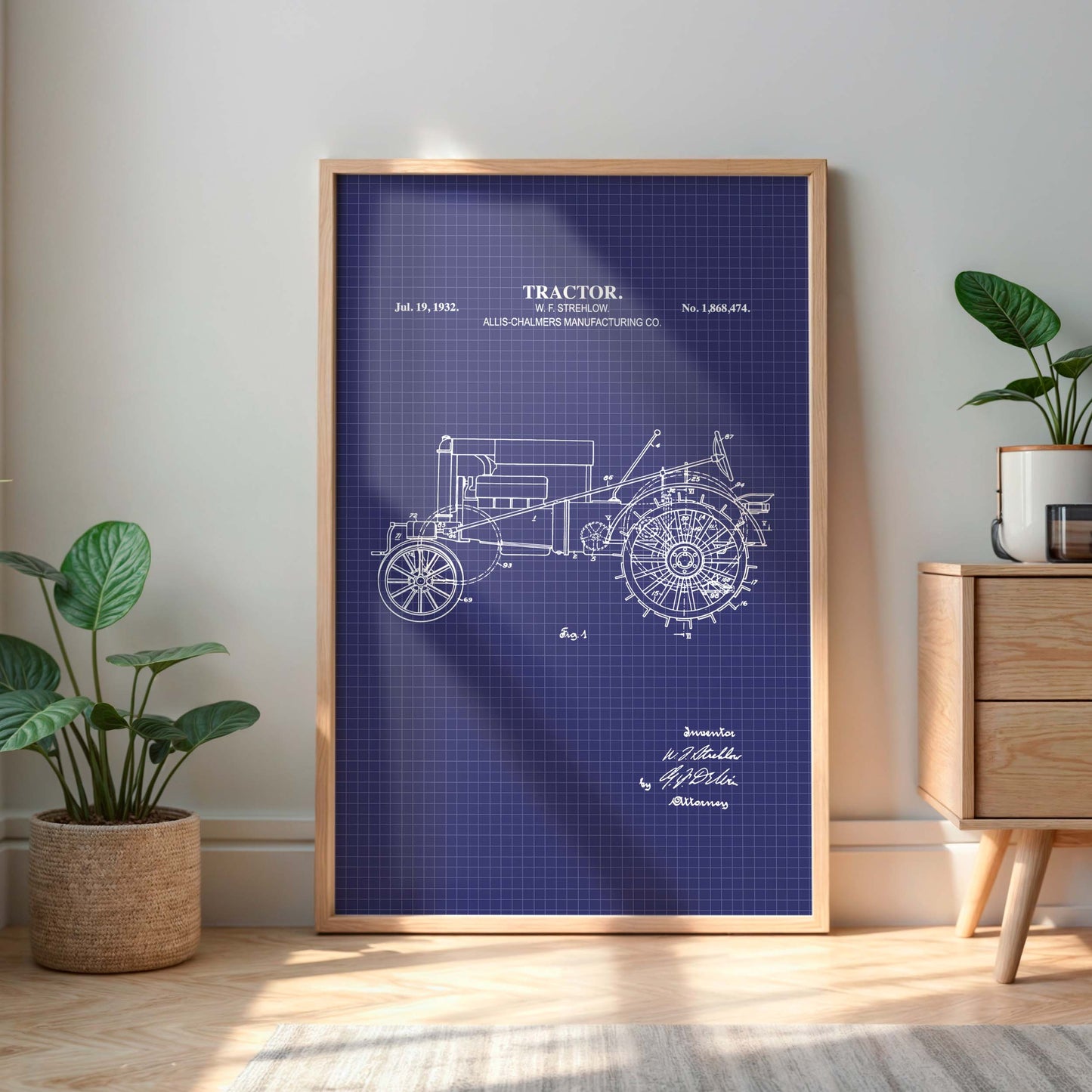Framed tractor blueprint on a wall with plants and a cabinet in the background